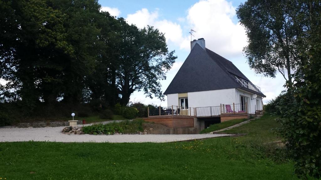 a small white building with a black roof at Kerprimel in Saint-Thois