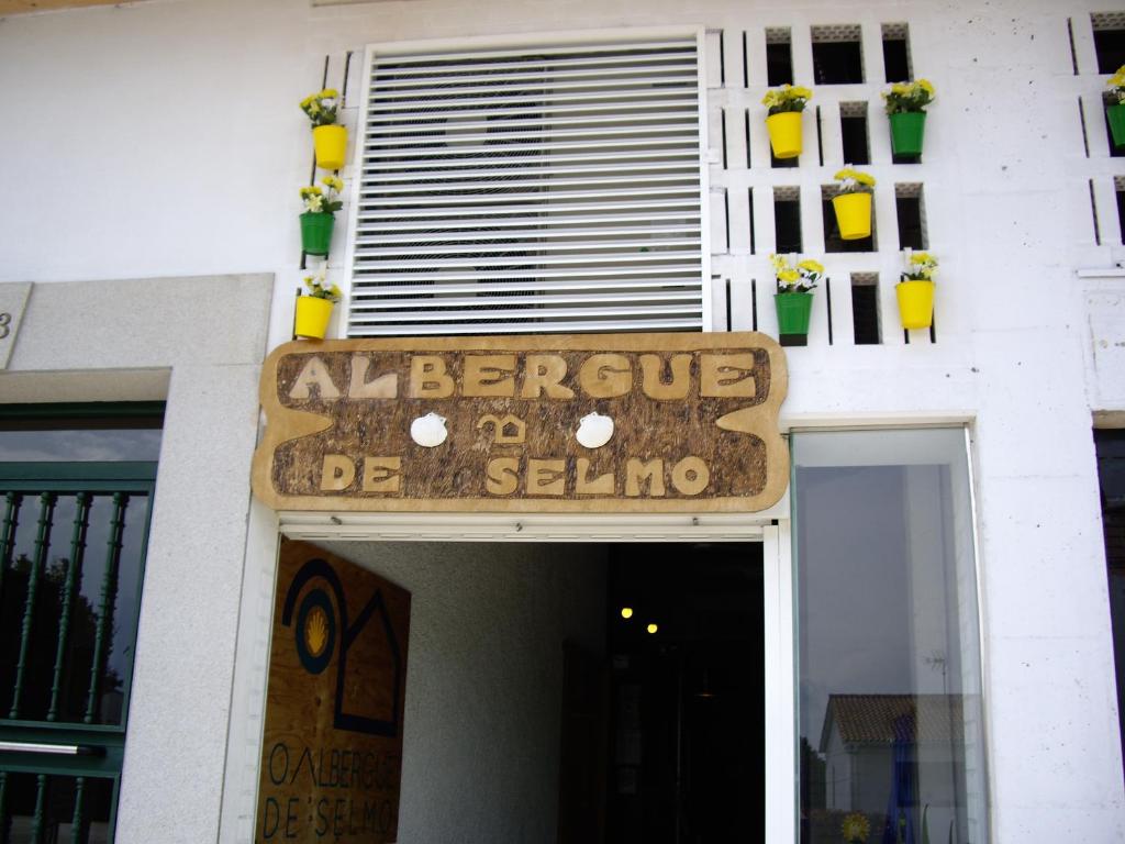 Un cartello che dice algarve de seula su un edificio di O Albergue de Selmo a Arzúa