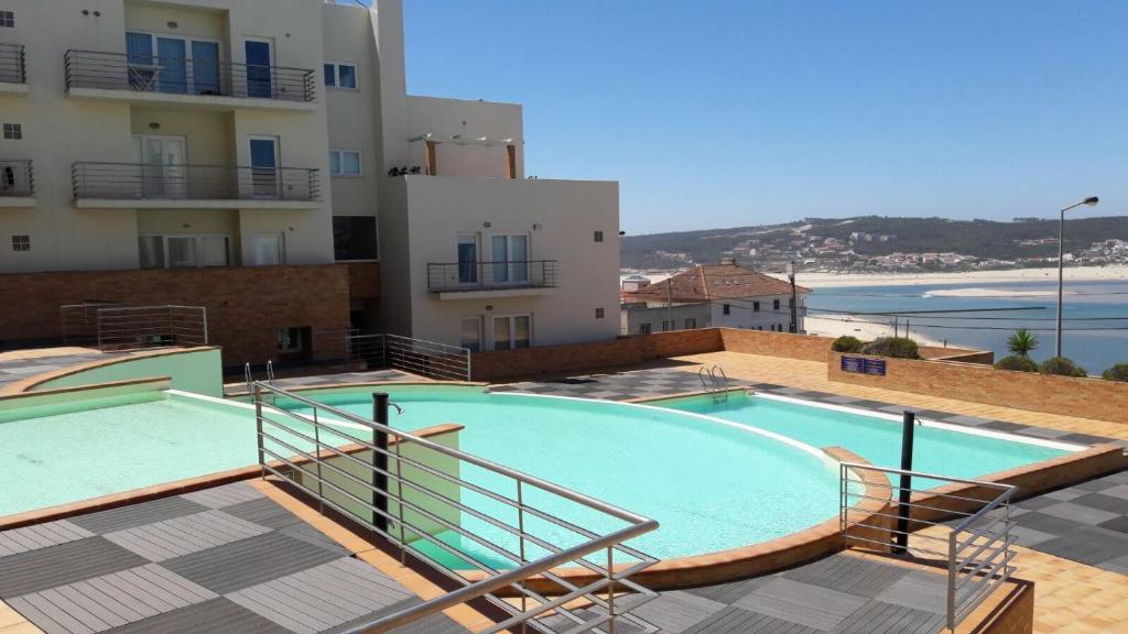 une grande piscine à côté d'un bâtiment dans l'établissement Pé na Praia da Foz, à Foz do Arelho