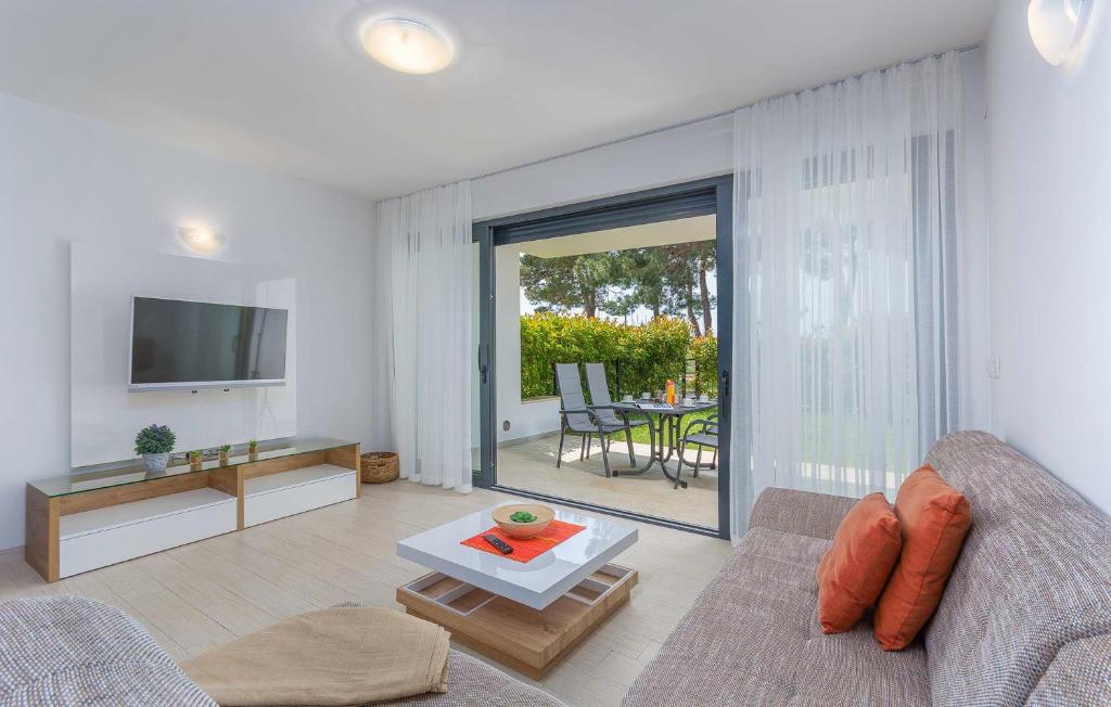 uma sala de estar com um sofá, uma televisão e uma mesa em Apartment Marina em Novigrad Istria