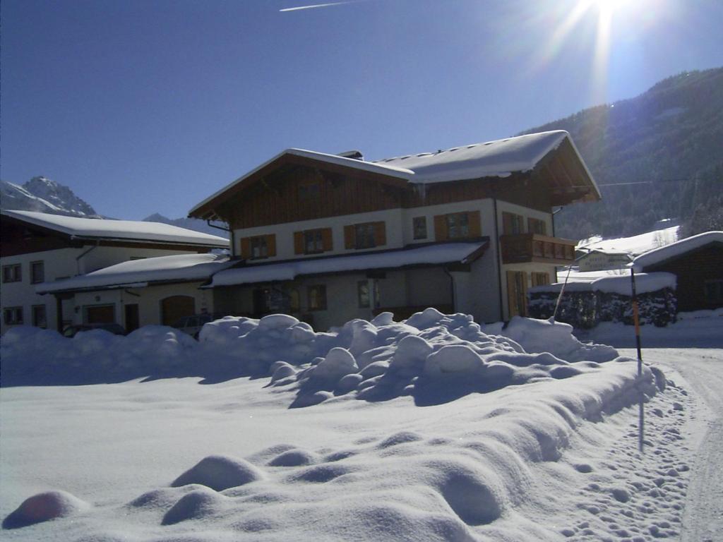 ein schneebedecktes Haus mit der Sonne dahinter in der Unterkunft Haus Buchsteiner in Radstadt