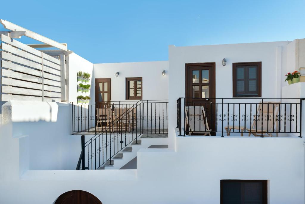 a white house with stairs and a balcony at Lindos Heart Apartments in Líndos