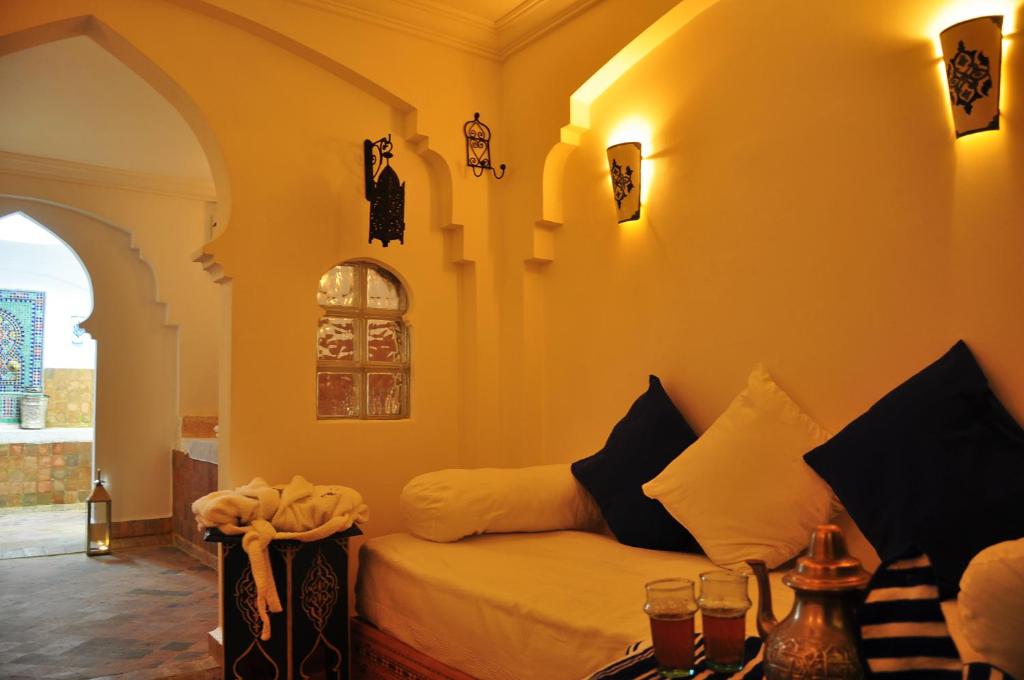 a living room with a couch and an archway at Hotel Al Alba Hammam & Restaurant in Asilah