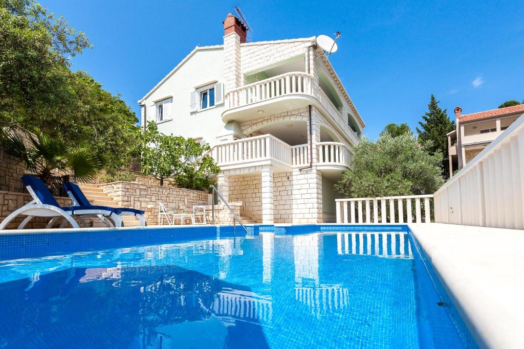 a house with a swimming pool in front of a house at Villa Matic in Vela Luka