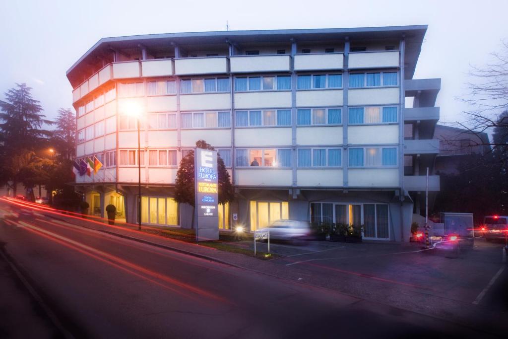 un edificio al lado de una calle con coches en Hotel Europa, en Reggio Emilia