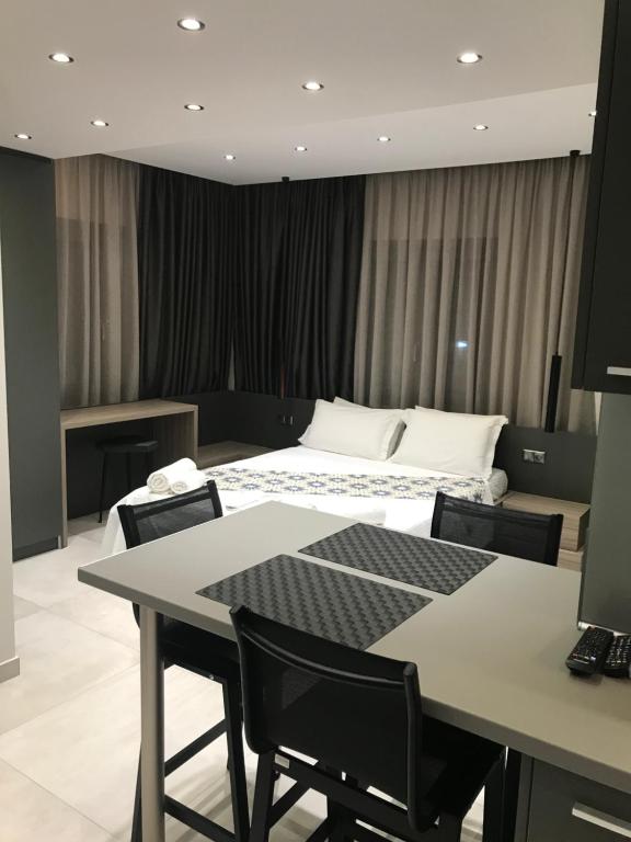 アスプロヴァルタにあるB. U. Luxury Apartmentsのベッドルーム1室(ベッド1台、テーブル、椅子付)