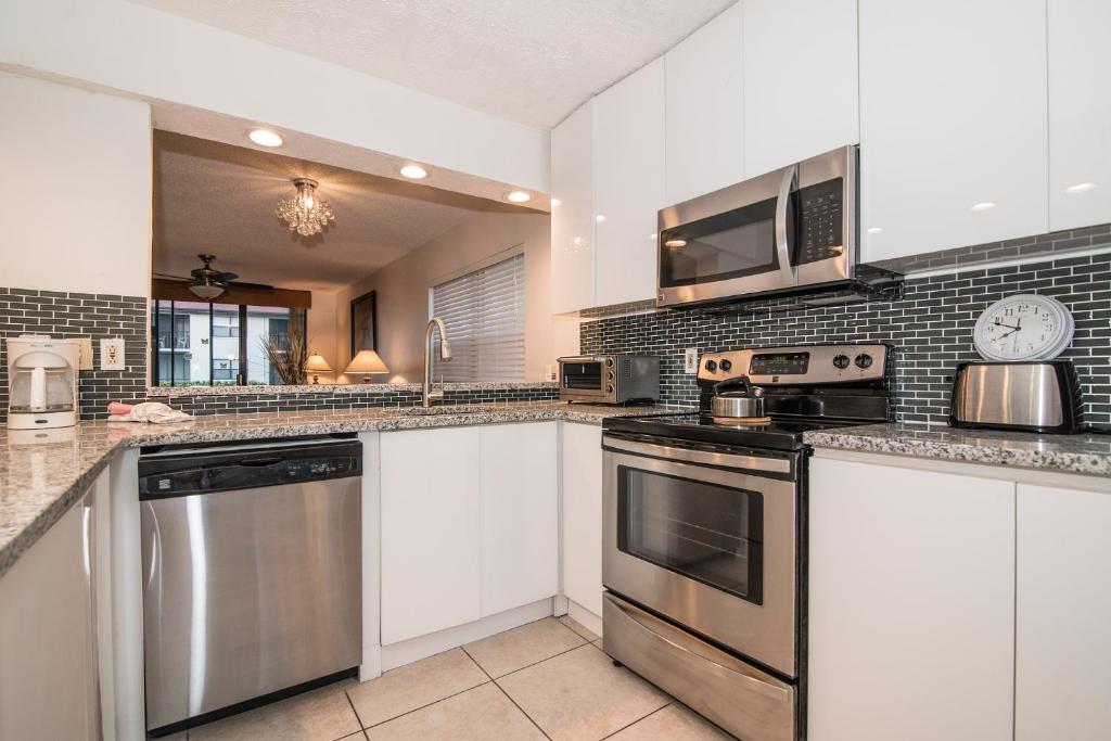 a kitchen with white cabinets and stainless steel appliances at Luxury Shorewalk Water Front 2 Bedroom 2 Bathroom 3Mins IMG 5 Mins Beach in Bradenton Beach