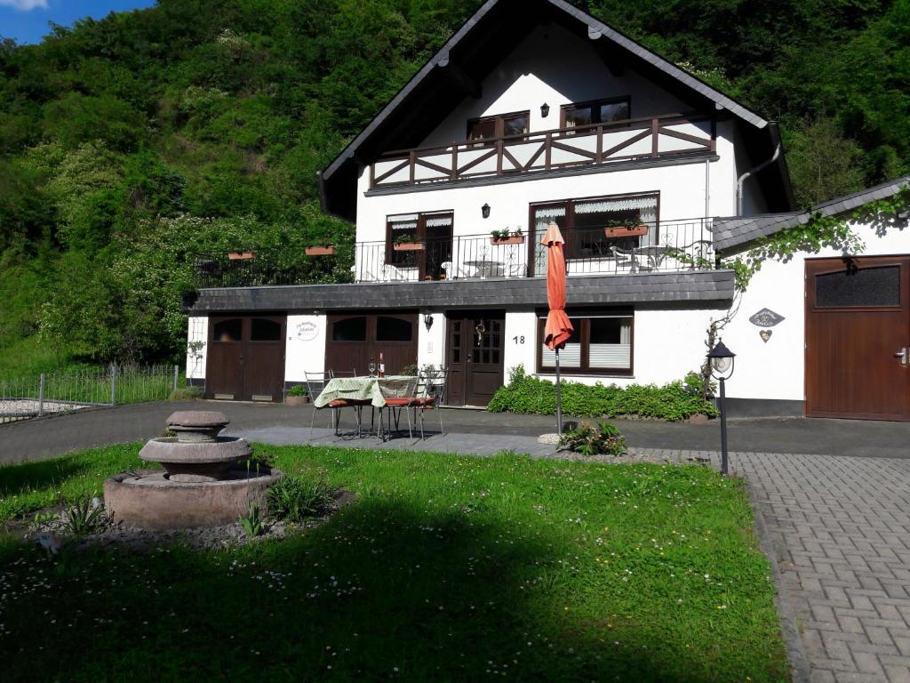 a white house with a black roof and a patio at Ferienhaus Jobelius in Beilstein