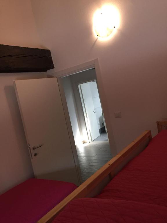 sypialnia z lustrem, łóżkiem i drzwiami w obiekcie Antica Contrada Marocco w mieście Riva del Garda