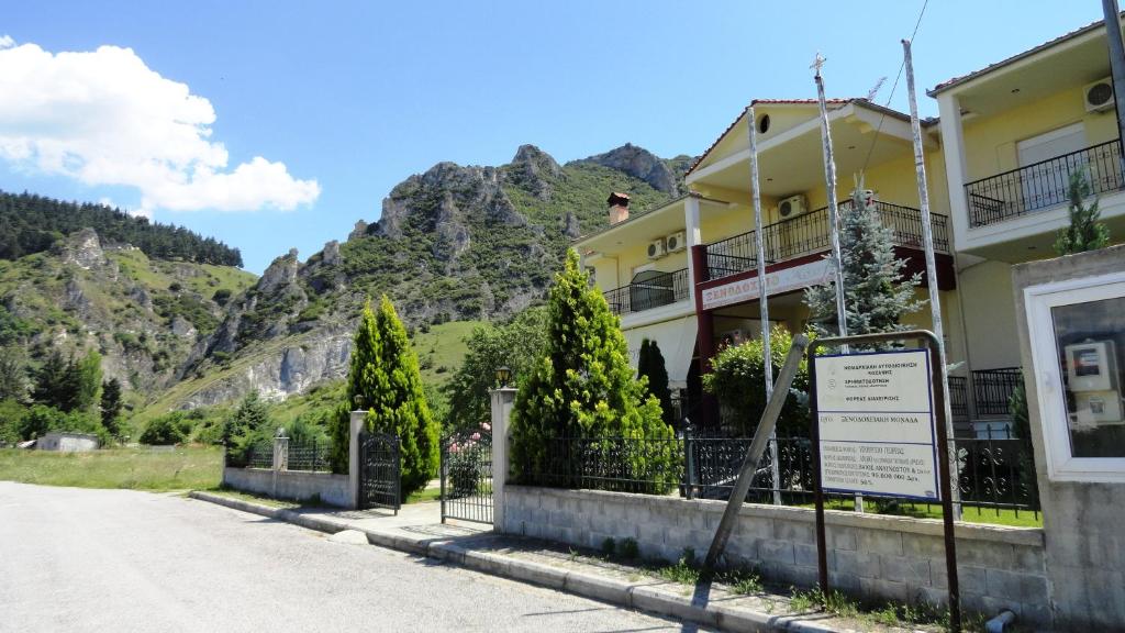 a building with a sign in front of a mountain at Hotel Kastro in Sérvia