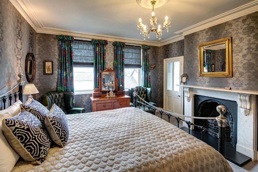 a bedroom with a large bed and a fireplace at Victoria House in Church Stretton