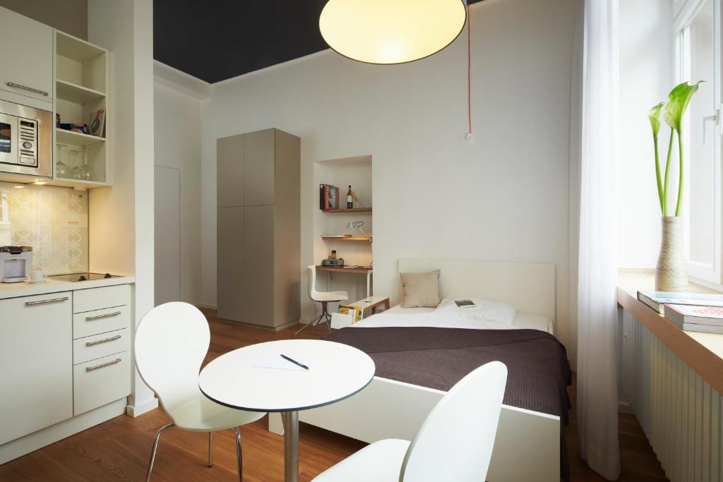 um quarto com uma cama, uma mesa e cadeiras em Aparthotel TU-TU em Essen