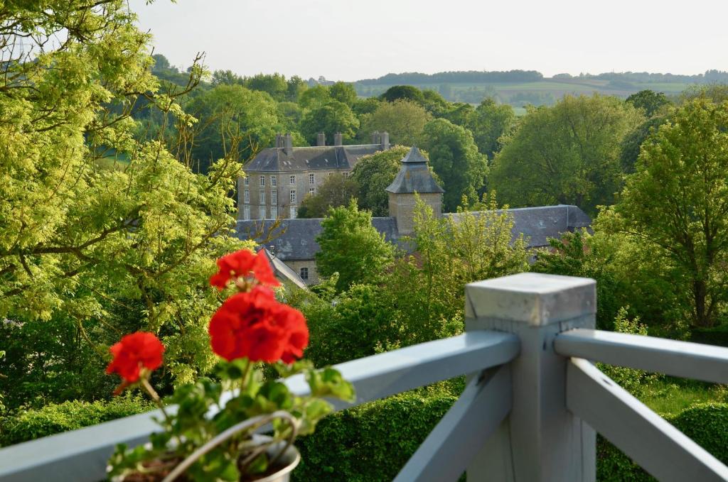 een vaas met rode bloemen op een wit hek bij L ' Authentique in Pernes-lès-Boulogne