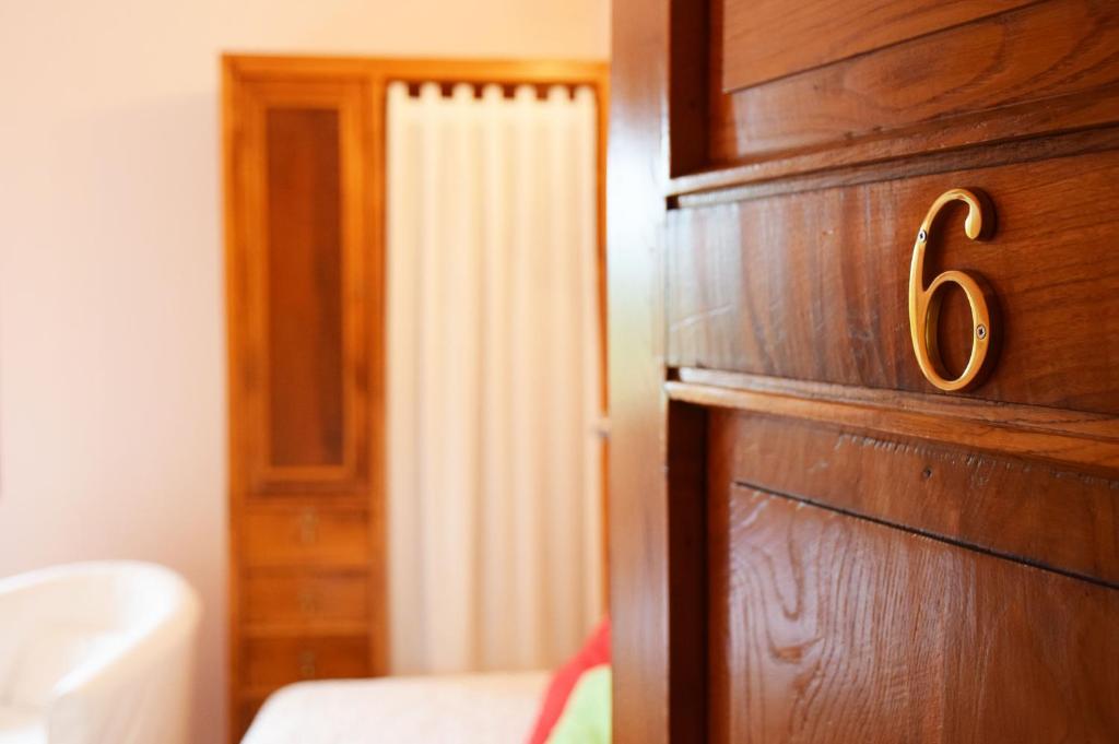 a bedroom with a wooden door with the number six at Hotel Hontoria in Hontoria