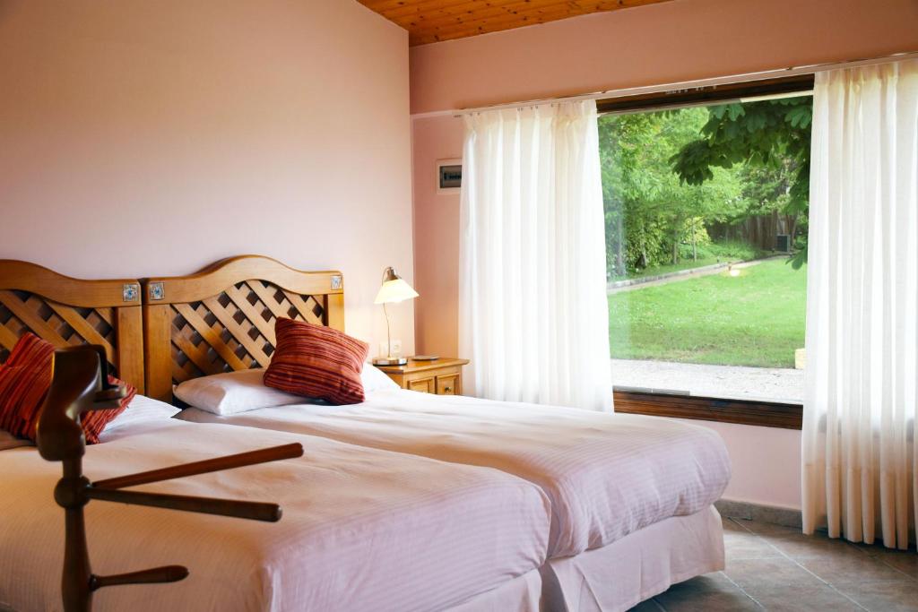 a bedroom with a bed and a large window at Hotel Hontoria in Hontoria