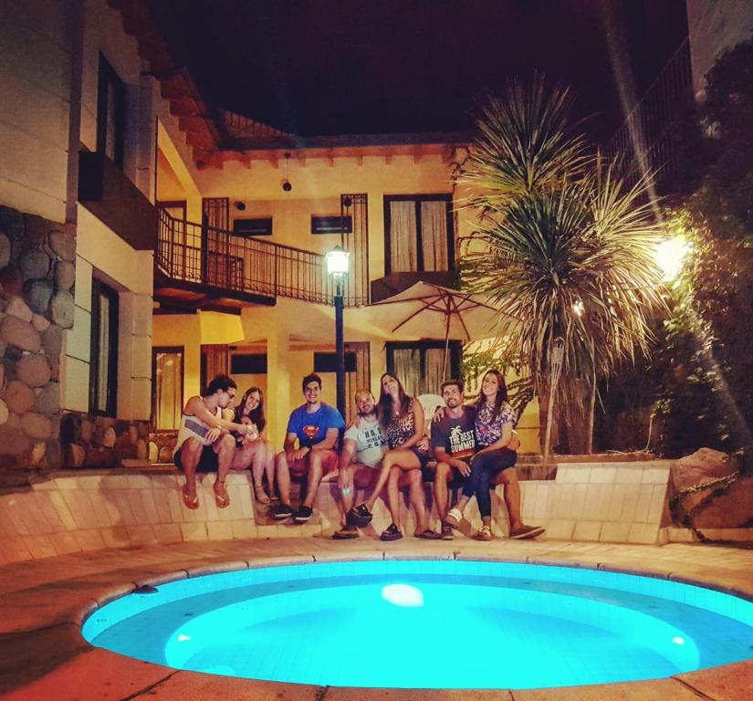 un grupo de personas sentadas alrededor de una piscina por la noche en La Magdalena en Mendoza