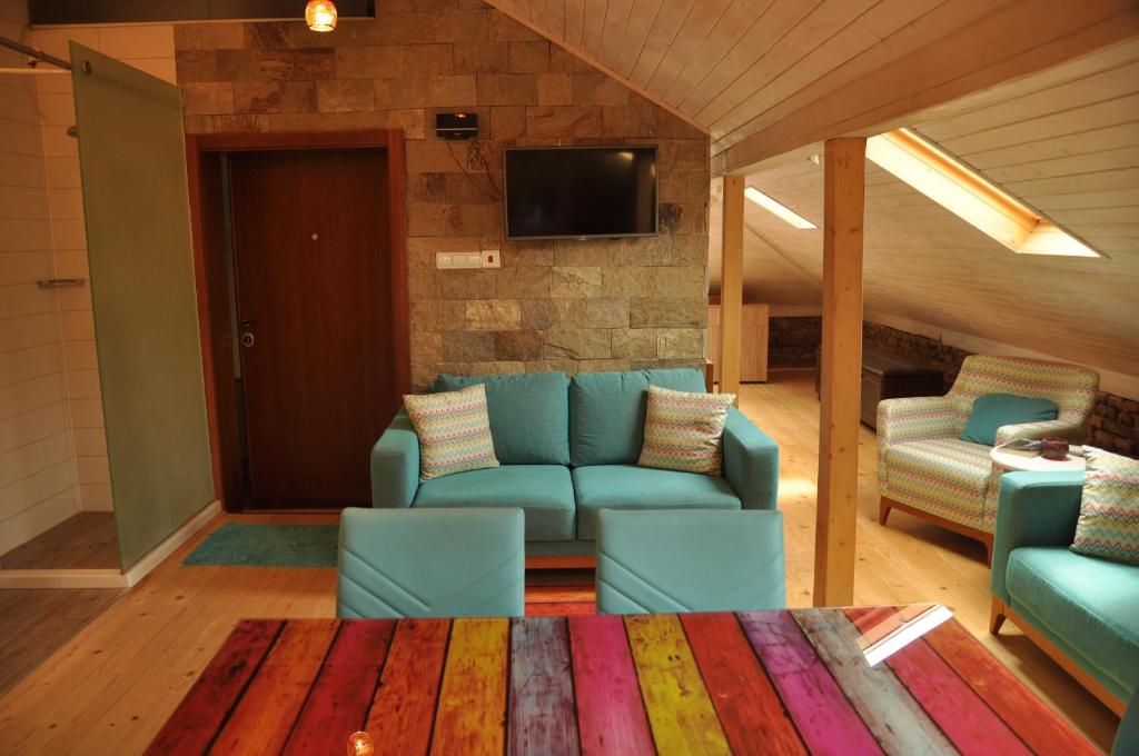 ein Wohnzimmer mit blauen Sofas und einem TV in der Unterkunft Ema Artistic House in Plewen