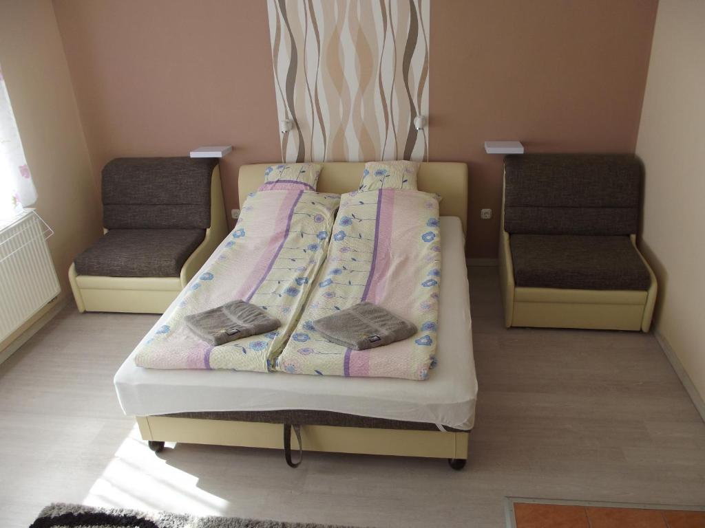 ハイドゥソボスローにあるLevendula Apartmanの小さなベッド1台(椅子2脚付)