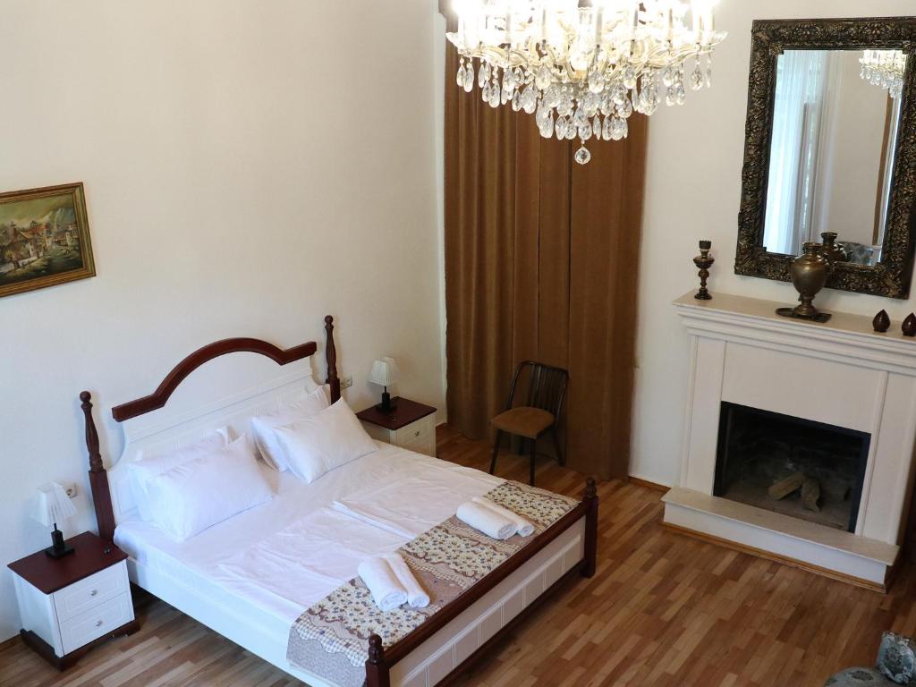 a bedroom with a bed with a fireplace and a chandelier at Liberty Apartment And Rooms in Tbilisi City