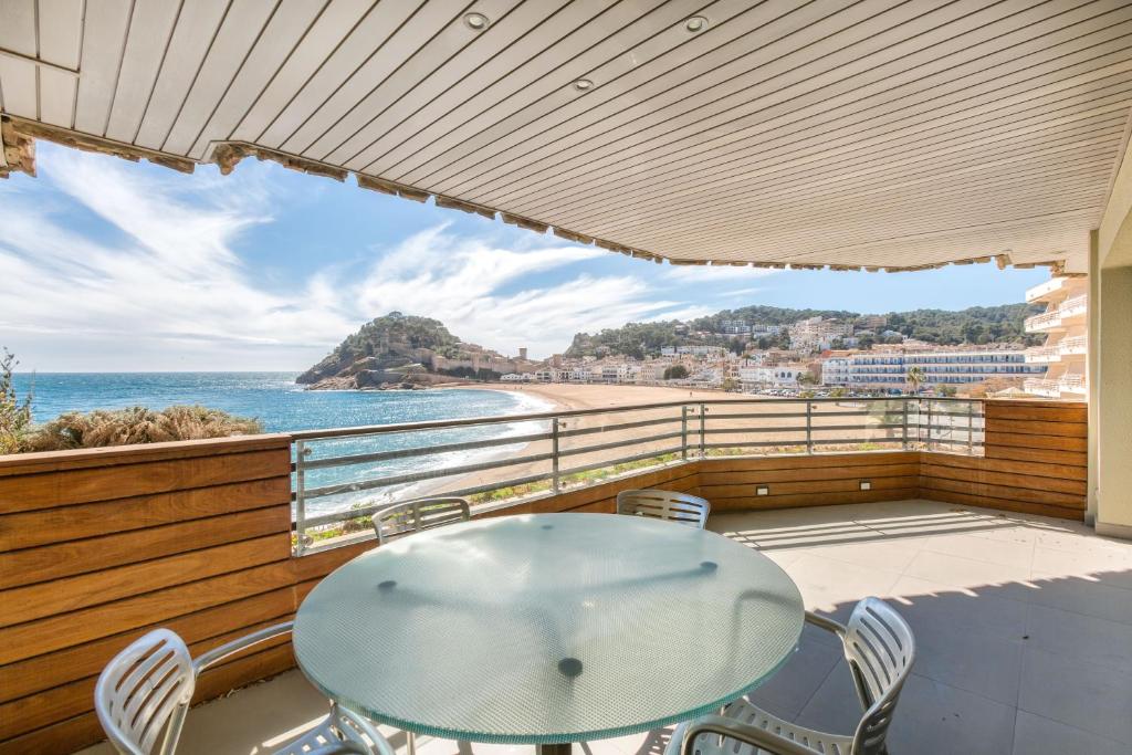 a balcony with a table and chairs and the ocean at Tossa de Mar Beach in Tossa de Mar