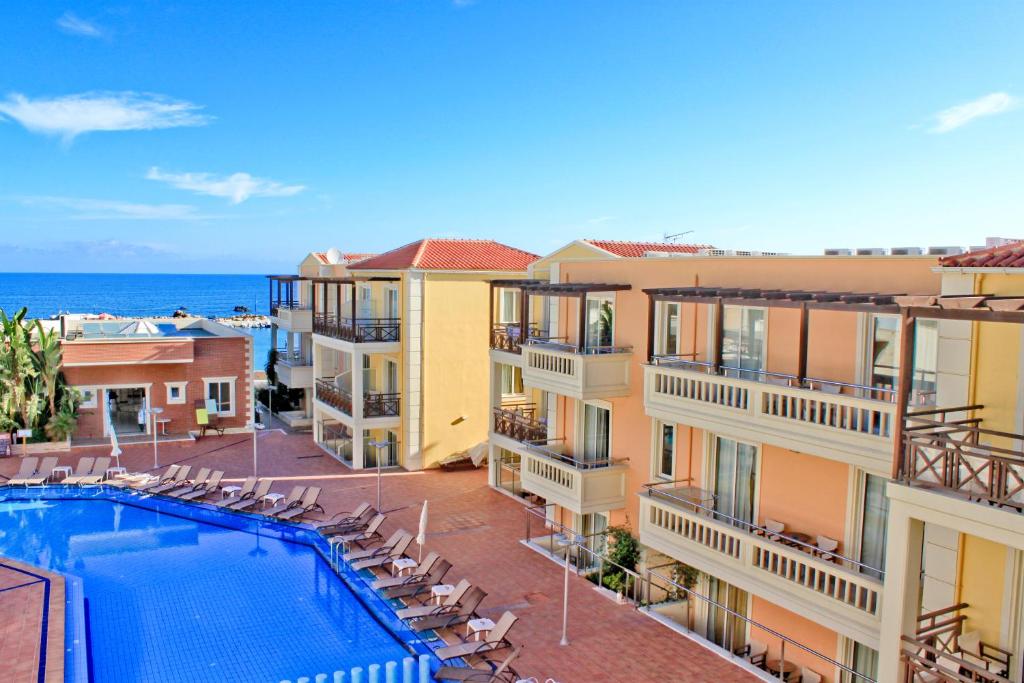 a view of a hotel with a swimming pool and the ocean at Porto Kalamaki Hotel in Kalamaki