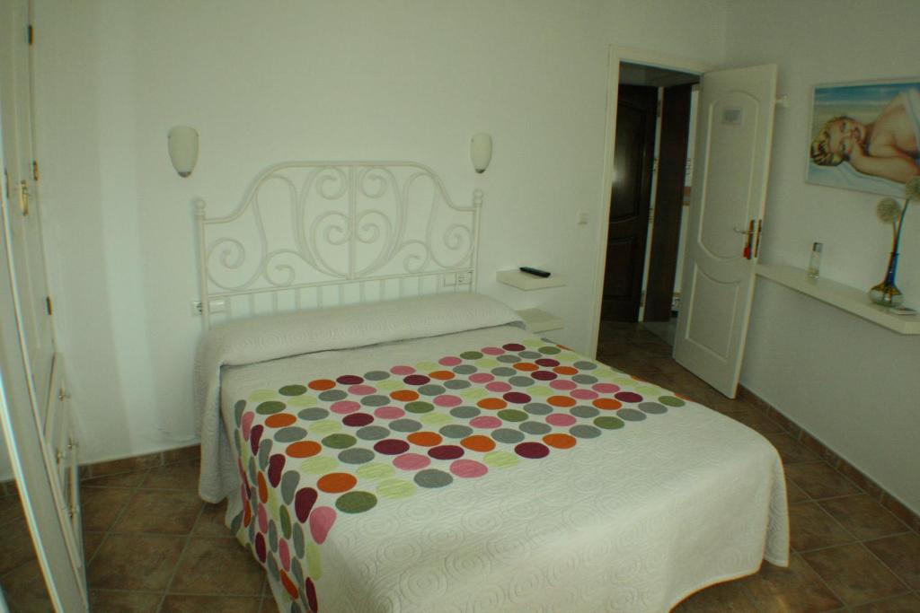1 dormitorio con 1 cama con manta de lunares en El Rincón de Isabel, en Conil de la Frontera