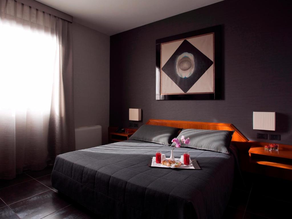 Un dormitorio con una cama con una bandeja de comida. en Hotel Zone en Roma
