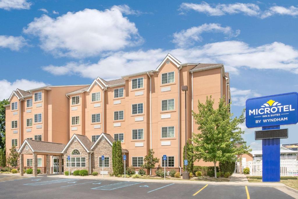 a hotel with a sign in front of a building at Microtel Inn & Suites by Wyndham Tuscumbia/Muscle Shoals in Tuscumbia