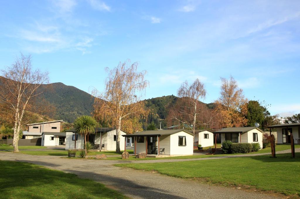 una fila de cabañas frente a una montaña en Parklands Marina Holiday Park, en Picton