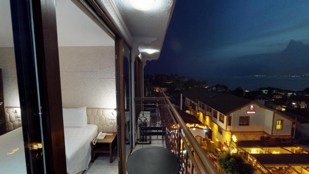 a room with a bed and a balcony with a view at Patron Hotel in Antalya
