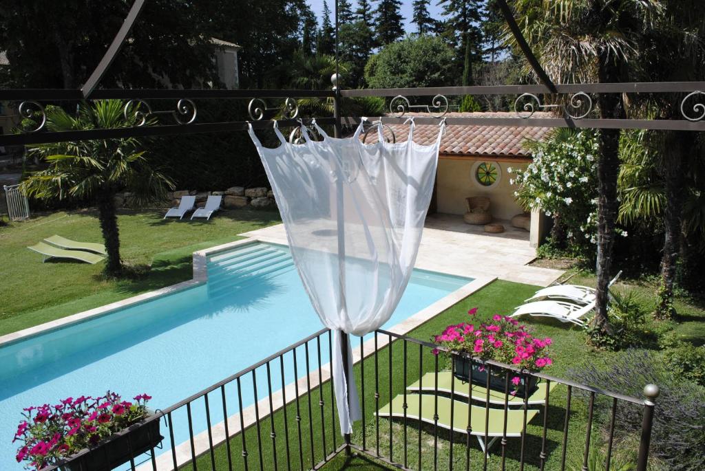 a white umbrella sitting next to a swimming pool at Domaine de Bellevue CHAMBRE D'HÔTES in Beaumes-de-Venise