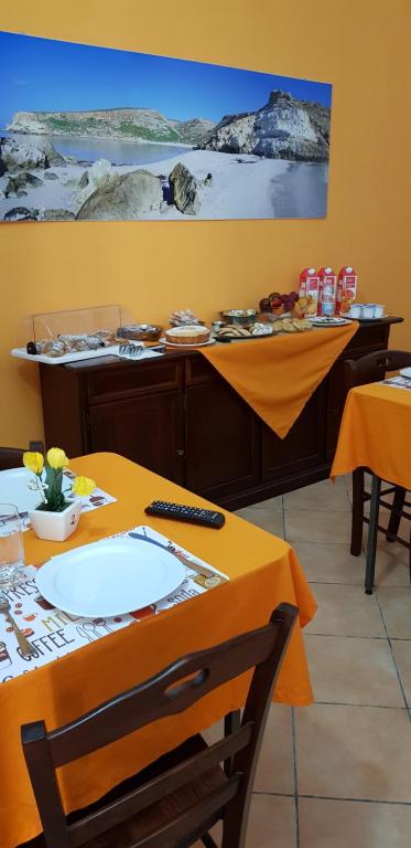 a dining room with a table with orange table cloth at B&B La Rosa Lampedusa in Lampedusa