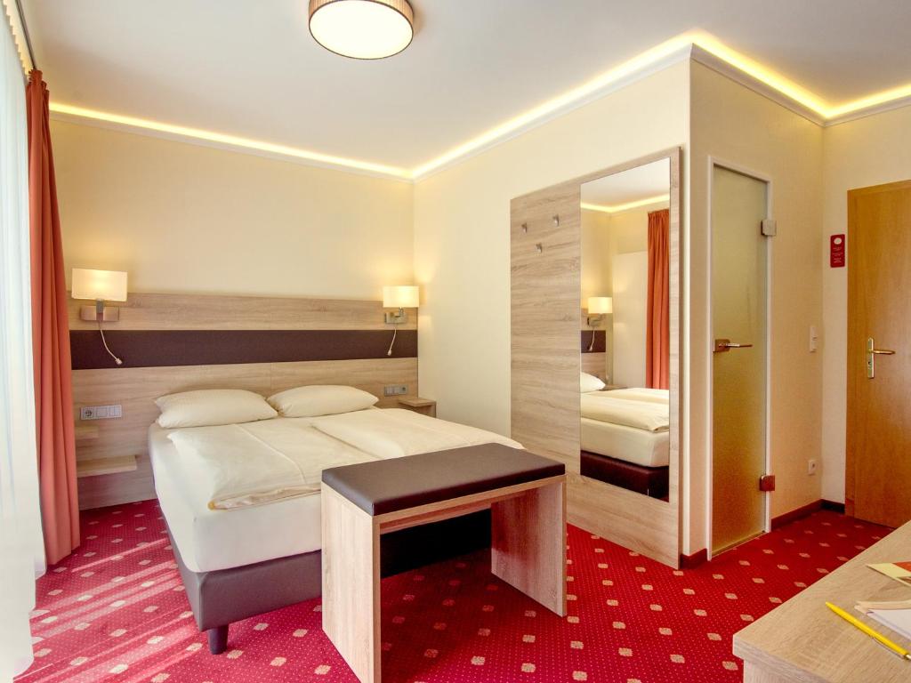 Postel nebo postele na pokoji v ubytování Hotel Kriemhild am Hirschgarten