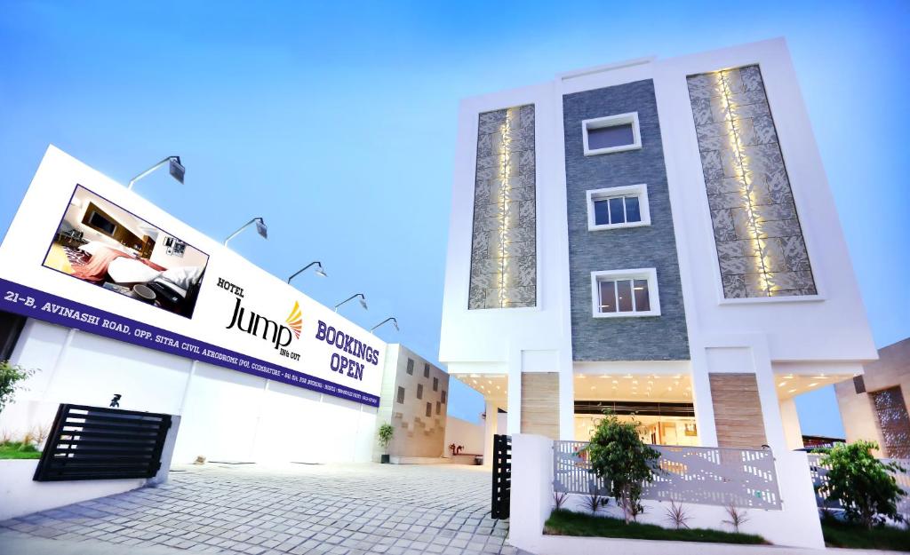 a large white building with two large windows at Hotel Jump In & Out in Coimbatore