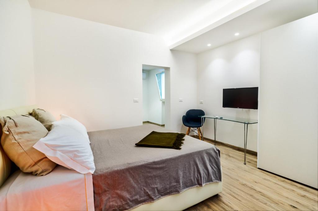 Schlafzimmer mit einem Bett, einem Schreibtisch und einem TV in der Unterkunft B&B ALUSEA in Silvi Paese