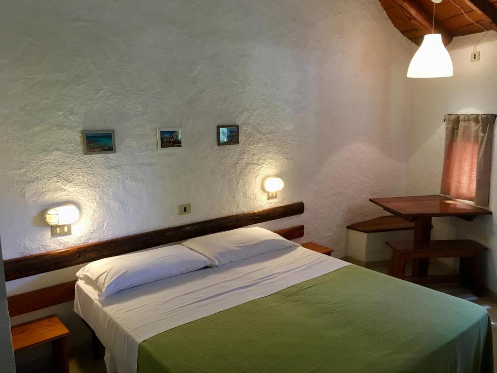 a bedroom with a bed with two lights on the wall at Cugnana Porto Rotondo Bungalows - Camping in Cugnana