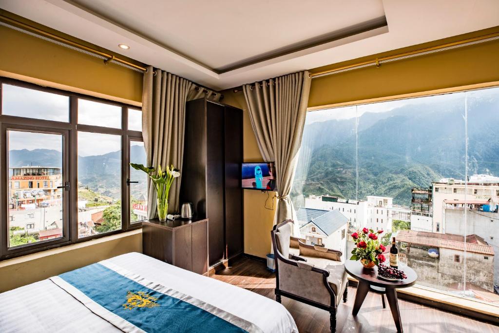 Un dormitorio con una cama y una mesa con flores. en Mimosa Hotel Sapa, en Sa Pa
