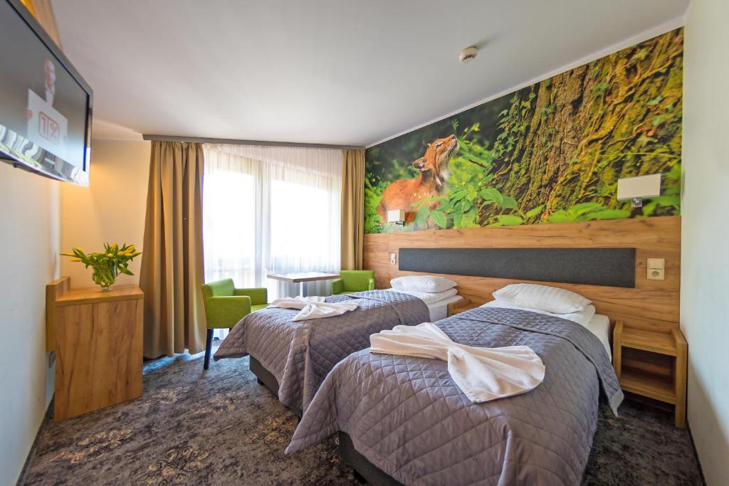 a hotel room with two beds and a painting on the wall at Góral Spa&Wellness in Szczyrk