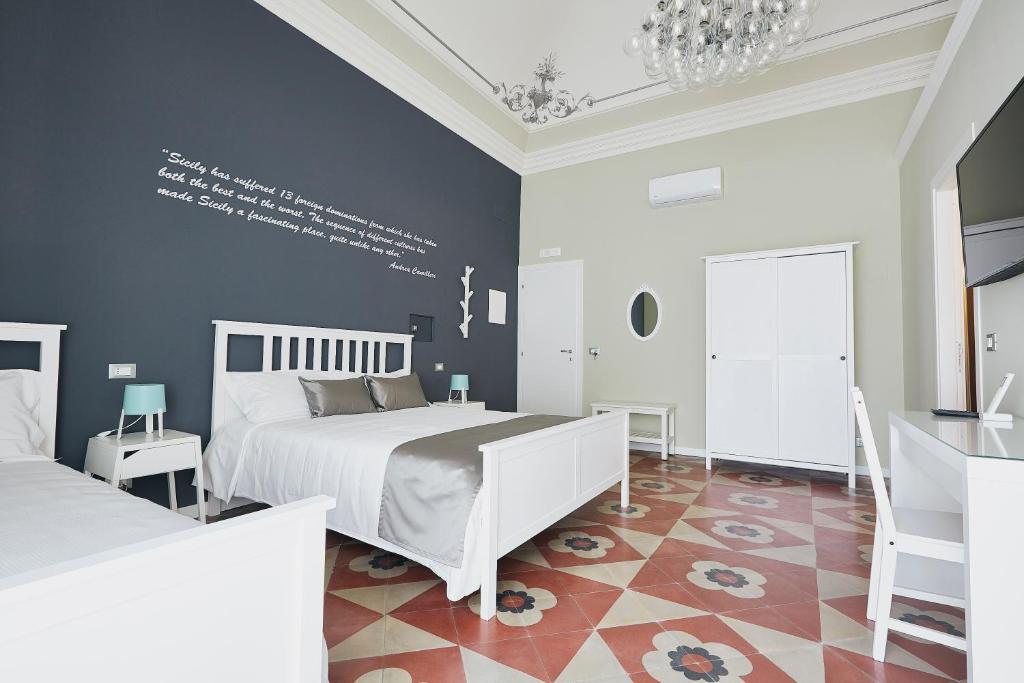 a bedroom with two beds and a blue wall at Corte dei medici - Palace in Catania