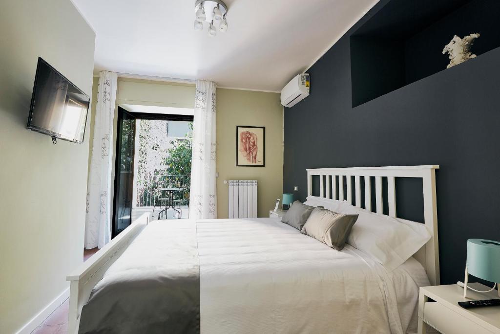 a bedroom with a large white bed and a window at Corte dei medici - Palace in Catania