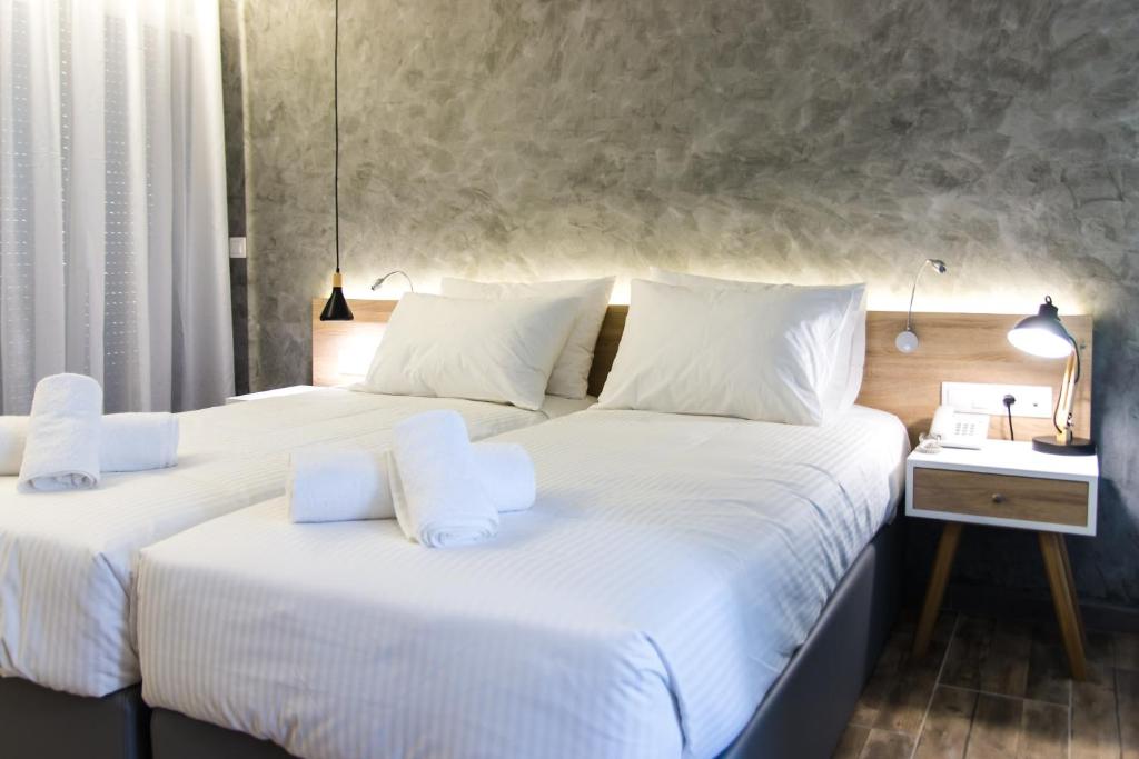 2 Betten in einem Hotelzimmer mit weißer Bettwäsche und Kissen in der Unterkunft Remis Studios in Rethymno