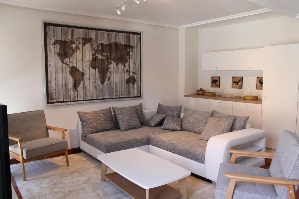 a living room with a couch and a map on the wall at PRECIOSO APARTAMENTO EN EL CENTRO - MAX. 6 PERSONAS in Ezcaray