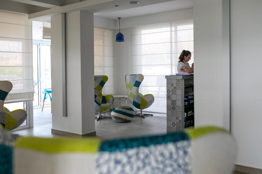 a woman sitting at a counter in a room with chairs at Marica's Boutique Hotel in Paphos