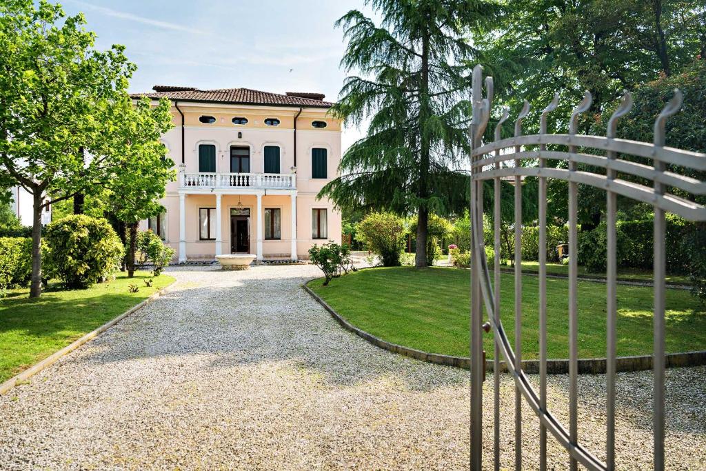 um portão em frente a uma grande casa branca em B&B Villa Romano em Treviso