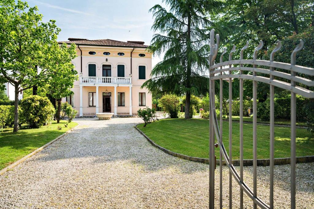 a gate in front of a large white house at B&B Villa Romano in Treviso