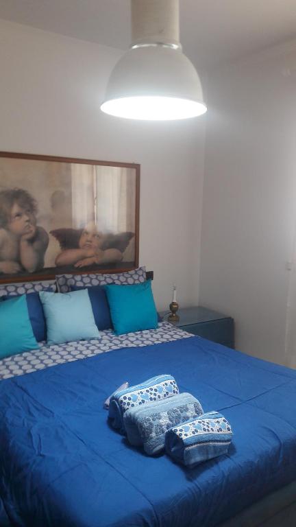 Un dormitorio con una cama azul con almohadas. en Via Borghetto di Vara 13 en Roma
