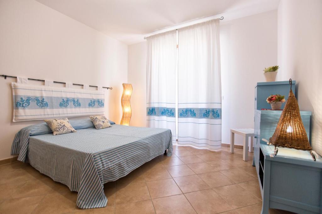 sypialnia z łóżkiem i oknem w obiekcie La Casa di Noemi w mieście Alghero