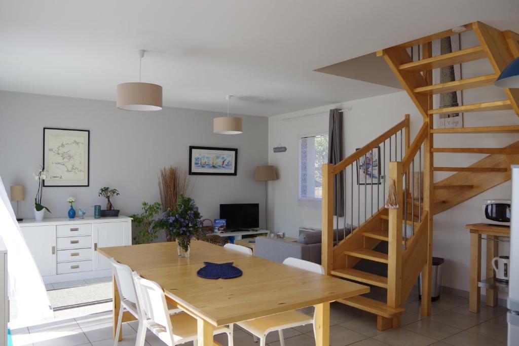 - une cuisine et une salle à manger avec une table en bois et des escaliers dans l'établissement Maison "Ouessant" Pays des Abers, à Plouguerneau