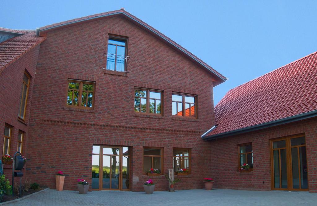un edificio de ladrillo rojo con ventanas laterales en Hof Hahnenberg, en Wagenfeld