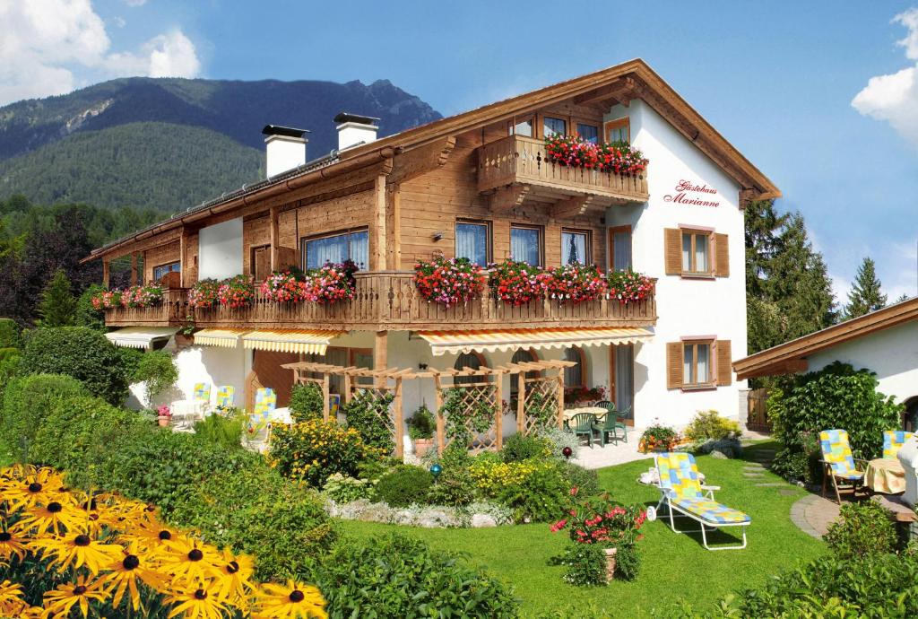 a building with a balcony with flowers on it at Gästehaus Marianne in Grainau